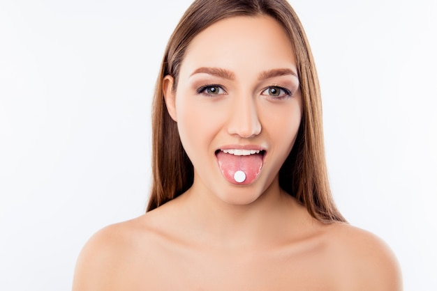 Close up portrait of girl with pill on her tongue