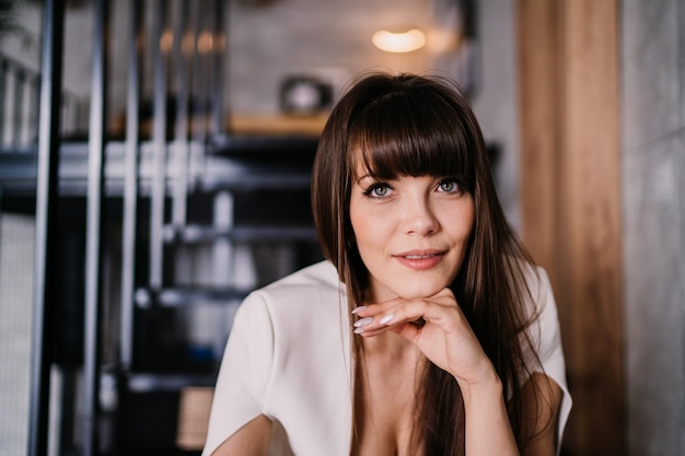 Close up portrait of gorgeous brunette young woman sitting on stairs at penthouse Luxury lifestyle a