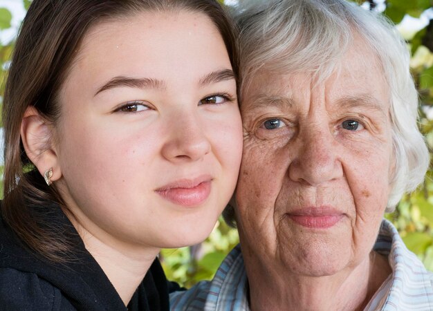 Photo close-up portrait of grandmother and granddaughter standing outdoors