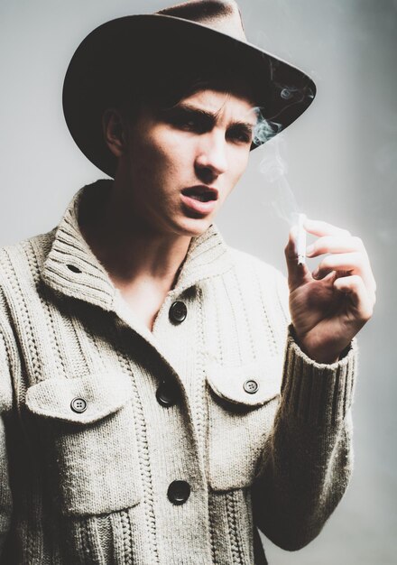 Photo close up portrait of guy in cowboy hat smoking