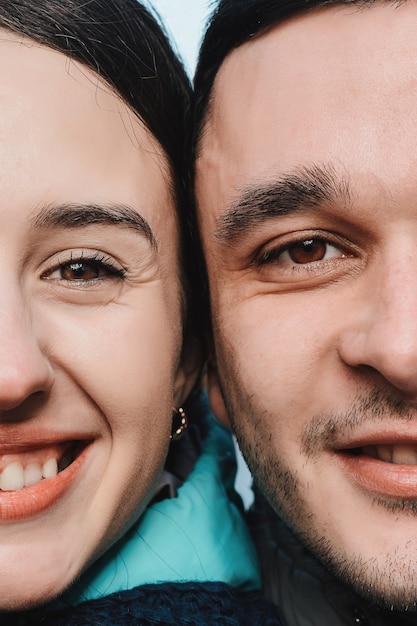 Close up portrait of half faces man and woman looking at camera. 