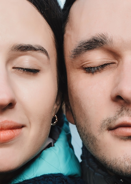 Close up portrait of half faces man and woman looking at camera. 