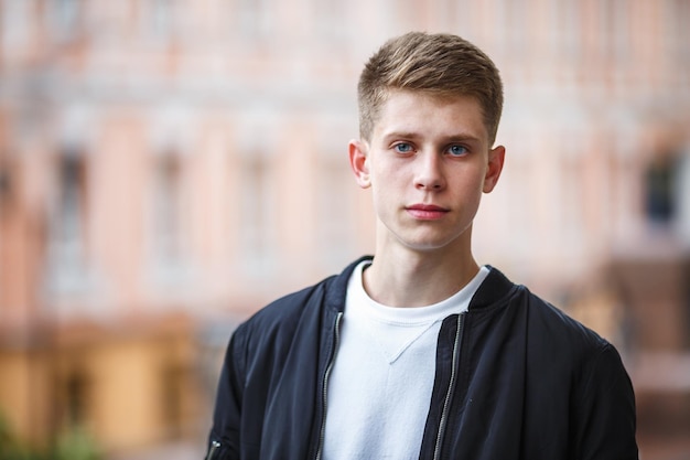 Close up portrait of handsome boy teenager in urban street background