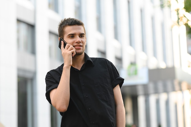 黒のシャツを着たハンサムな若い男の肖像画をクローズアップ