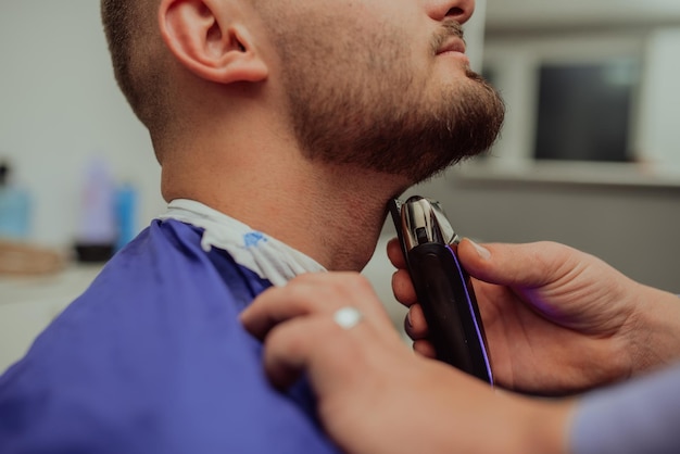 Close up portrait of a handsome young man getting beard shaving with a straight razor Focus on the blade Selective focus High quality photo
