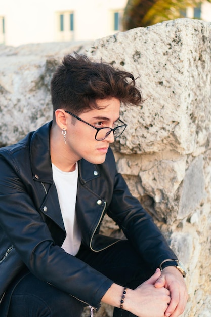 Close-up portrait of a handsome young man, sad in the open air