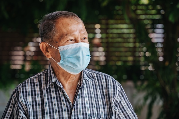 Close-up portrait of happy asian senior man wear a mask Look with hope. Old thai man