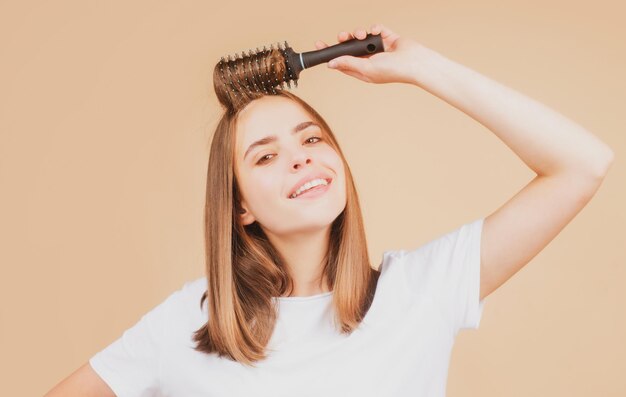 Close up portrait of happy beautiful girl with shiny hair with comb