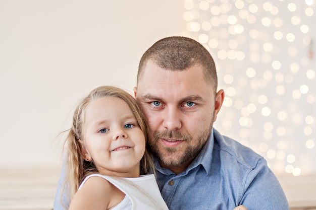 A close-up portrait of a happy father and a little daughter