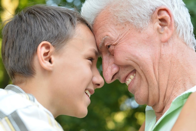 Close up portrait of happy grandfather and grandson in park