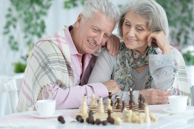 Close up portrait of happy senior couple playing chess together