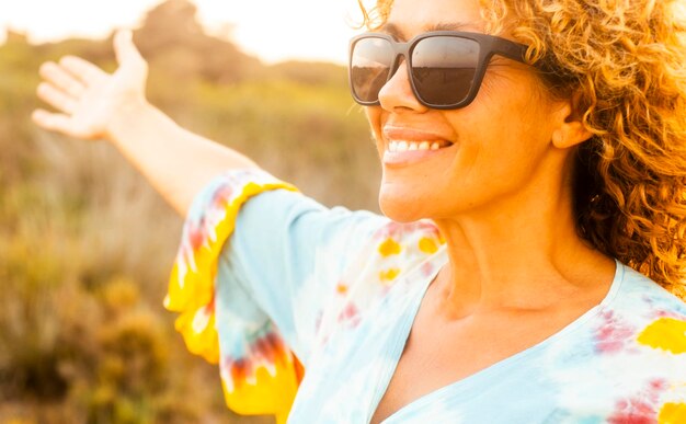 Close up portrait of happy young cute woman smiling and hugging nature enjoying freedom and joyful in sunset light time Outdoor leisure activity people Travel and destination Wellbeing and mindful