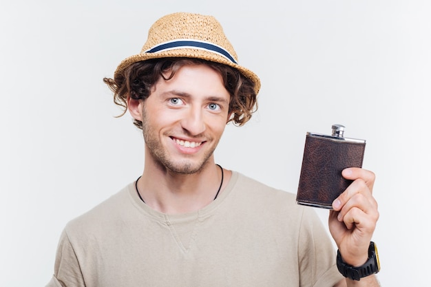 Close-up portrait of a happy young man holding alcohol flask isolated on the white background