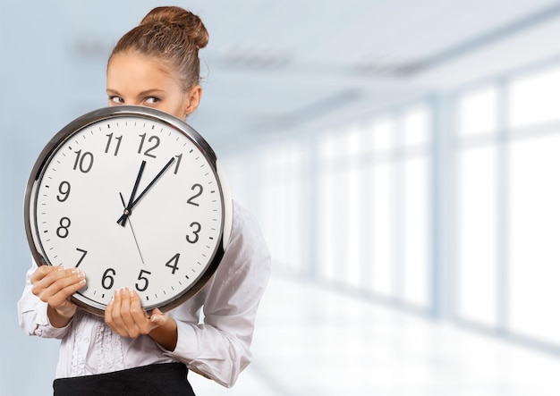 Close-up portrait of happy young woman with big clock