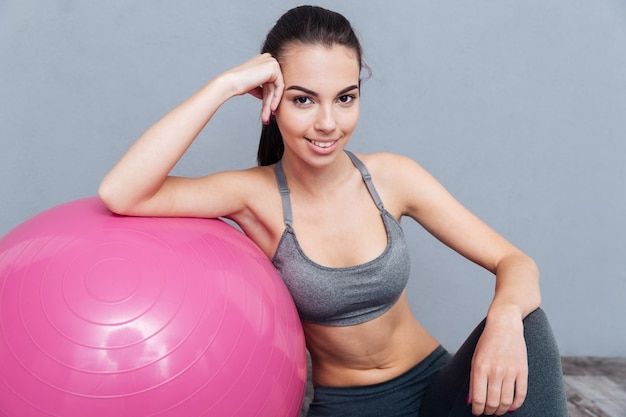 Close-up portrait of a healthy fitness girl isolated on grey background