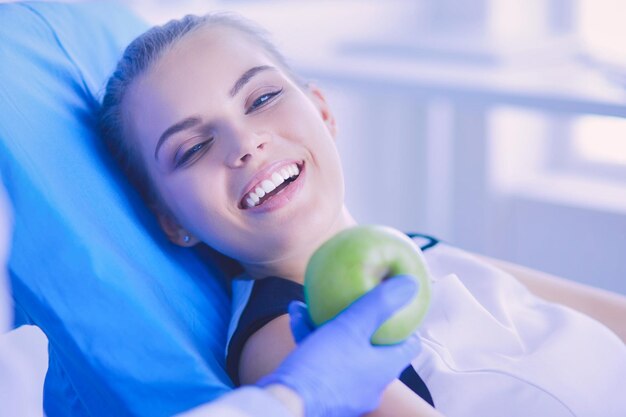 Close up portrait of healthy smiling woman with green apple