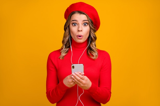 Close-up portrait of her she nice attractive amazed cheerful wavy-haired girl holding in hands cell listening podcast music pout lips isolated on bright vivid shine vibrant yellow color background