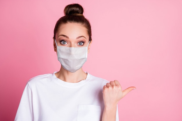 Close-up portrait of her she nice attractive amazed girl wearing safety mask showing copy space mers cov influenza prevention medicare novelty vaccine isolated pastel pink color background