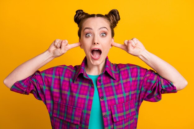 Close-up portrait of her she nice attractive lovely overwhelmed devastated girl wearing checked shirt closing ears ignore scandal isolated bright vivid shine vibrant yellow color background