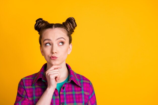Photo close-up portrait of her she nice attractive pretty girl wearing checked shirt learning memorizing copy space touching chin isolated over bright vivid shine vibrant yellow color background