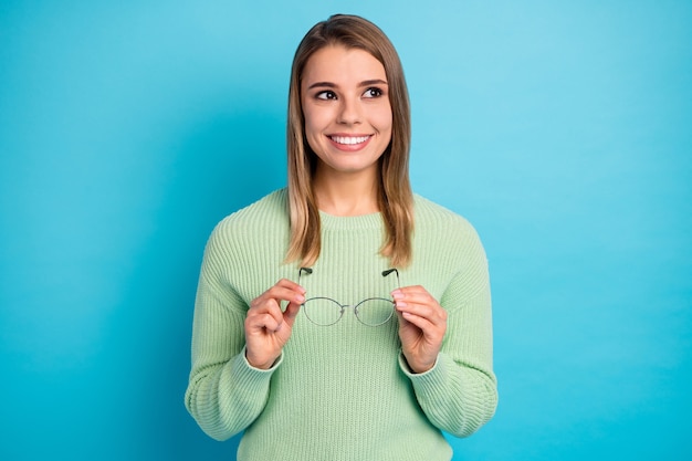 Close-up portrait of her she nice-looking attractive lovely pretty curious cheerful cheery girl holding in hands specs new vision isolated over bright vivid shine vibrant blue color background