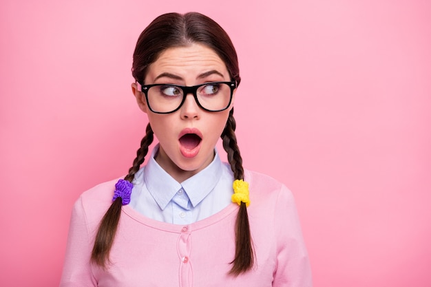 Close-up portrait of her she nice-looking attractive lovely pretty cute amazed stunned brown-haired teen girl geek looking aside strange news reaction isolated over pink pastel color background