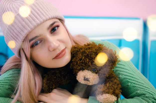 Close up portrait of hipster girl. Pretty girl hugs toy bear