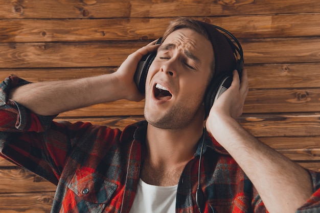 Close up portrait of hipster man listening music and singing