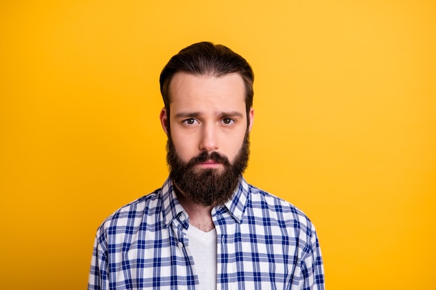 Close-up portrait of his he nice attractive disappointed brunette bearded guy wearing checked shirt