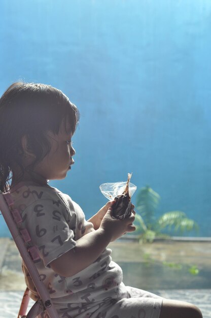 Close up portrait of little asia girl eating expression