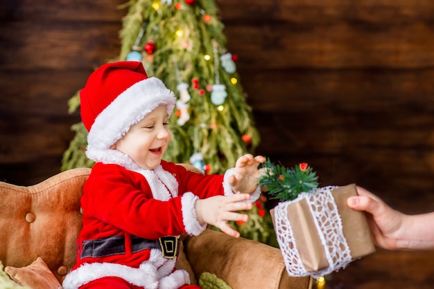 Ritratto del primo piano di un ragazzino vestito come un babbo natale rosso