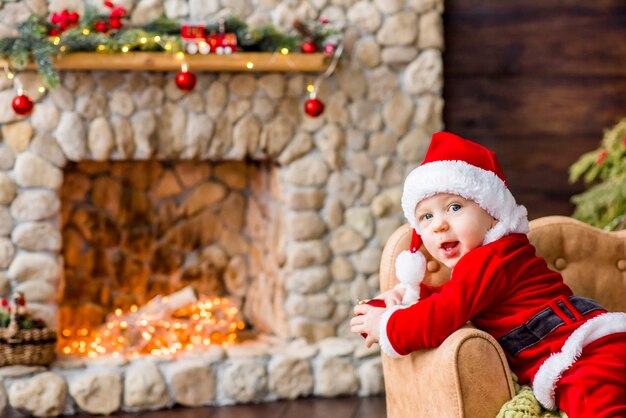Крупным планом портрет маленького мальчика в костюме красного Санта-Клауса