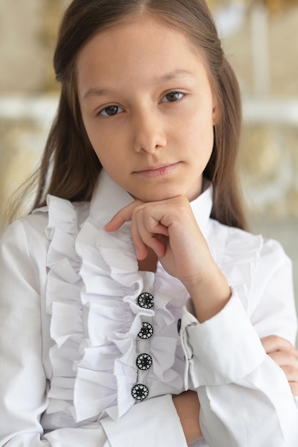 Close up portrait of little girl in white blouse posing