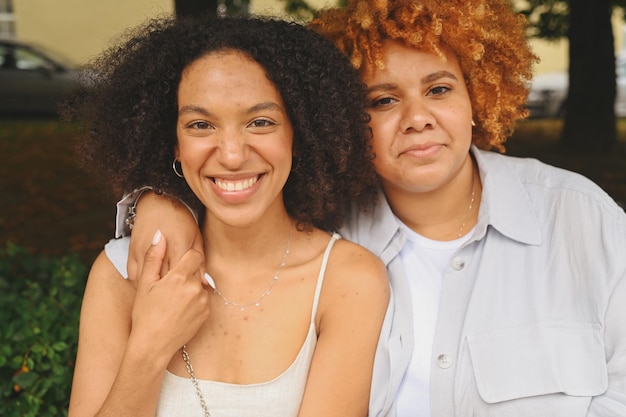 Close up portrait lovely beautiful happy lesbian african american couple hugging around city street