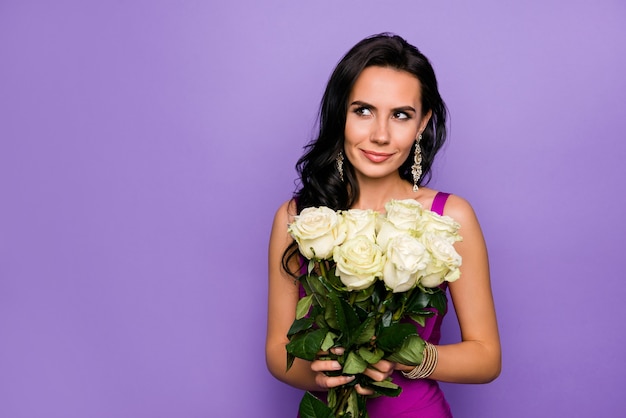 Close up portrait of lovely lady holding roses isolated over purple color background