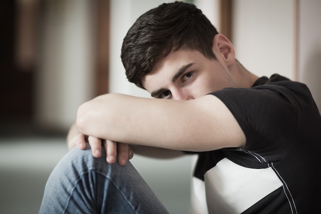 Close-up portrait of male student with head on knees