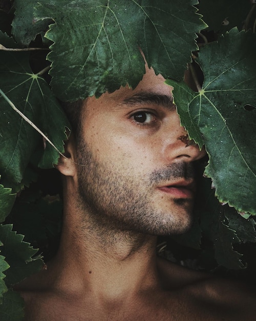 Photo close-up portrait of man by leaves