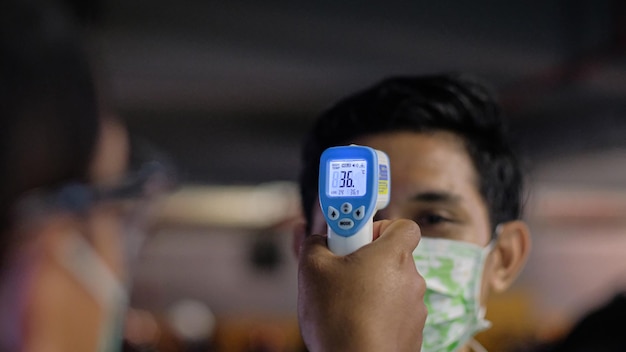 Photo close-up portrait of man checking temperature