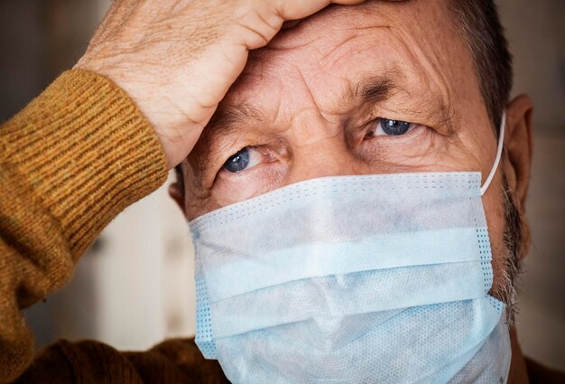 Photo close-up portrait of man covering face in medical mask