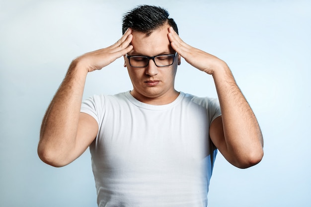 Close-up portrait of a man, covering his face with his hands. 