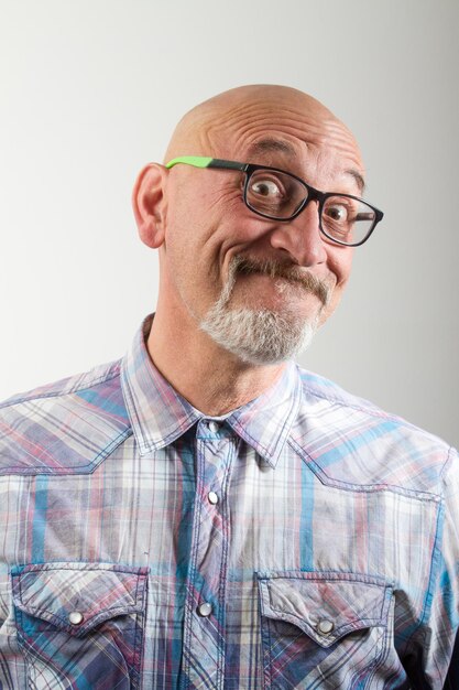 Foto ritratto ravvicinato di un uomo con gli occhiali sullo sfondo grigio