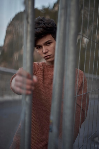 close-up portrait of man looking through fence
