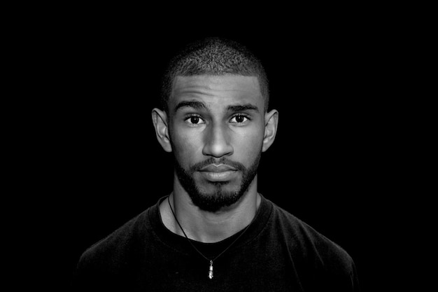 Photo close-up portrait of man standing against black background