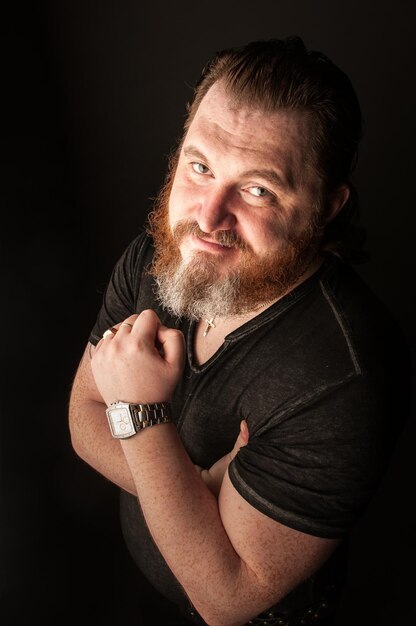 Close-up portrait of man with beard against black background