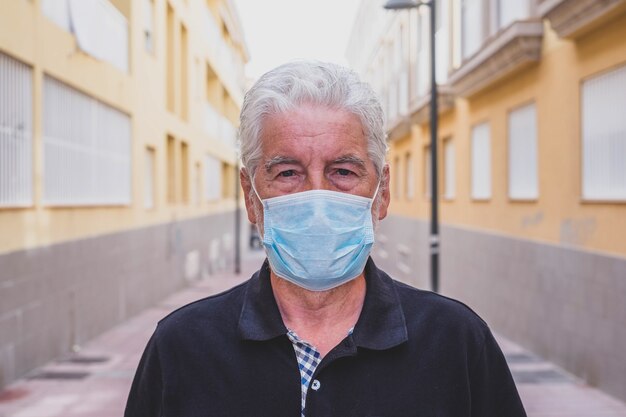 Close up and portrait of mature man wearing medical mask preventing virus or any type of disease