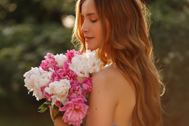 Close-up portrait of a model with flowers in summer. walk in the park in spring. blurred background