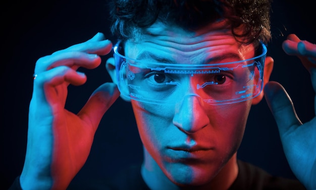 Close up portrait Neon lighting Young european man is in the dark studio