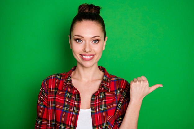 Close-up portrait of nice-looking attractive lovely confident cheerful cheery girl in checked shirt showing decision copy empty space isolated on bright vivid shine vibrant green color background