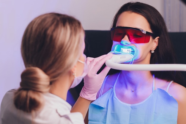 Фото Крупным планом портрет пациентки, посещающей стоматолога для отбеливания зубов в клинике, процедуры отбеливания зубов.