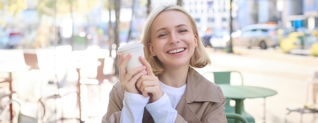写真 笑う笑う若い女性がコーヒーを飲んで幸せに見えるクローズアップの肖像画